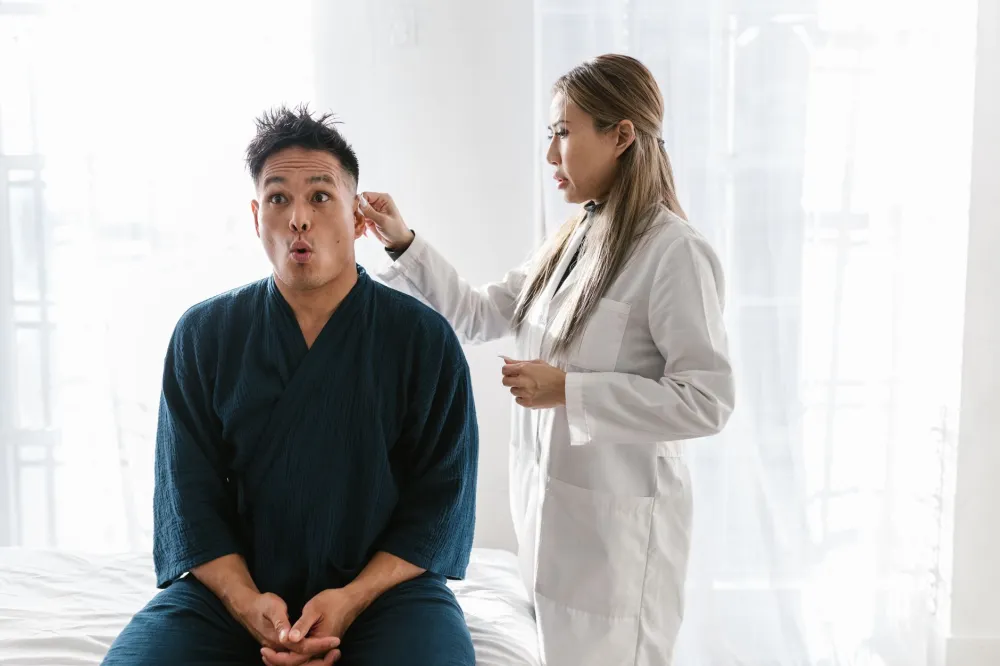 Pimple Inside the Nose: Causes and When to See a Doctor 4 Doctor examining a patient's nose for signs of nasal infection or serious pimple