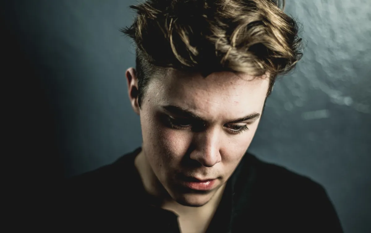 Thoughtful young man sitting on his bed wondering about a pimple on foreskin