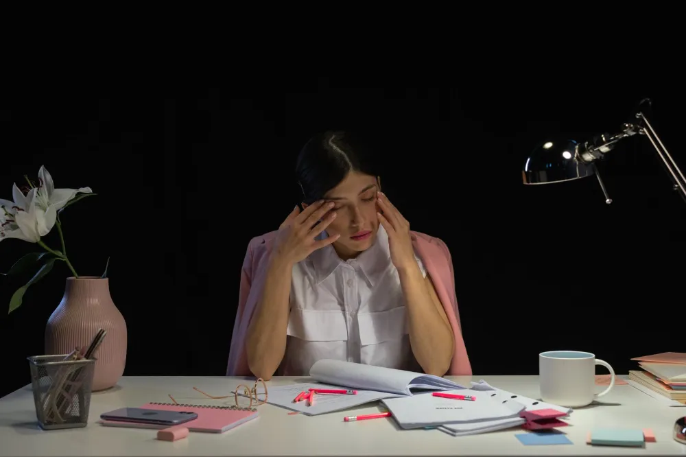 Pimple vs Cold Sore: 7 Simple Clues to Tell Them Apart 3 Tired, stressed woman at her desk, a common trigger for a fever blister outbreak