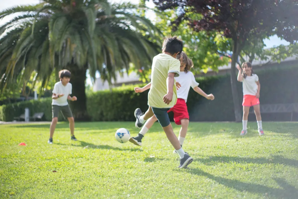 Children playing and running outside in a sunny backyard