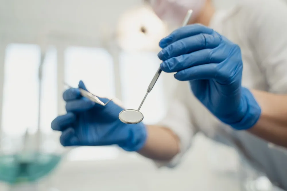 Dentist examining swollen gum around one tooth with dental mirror