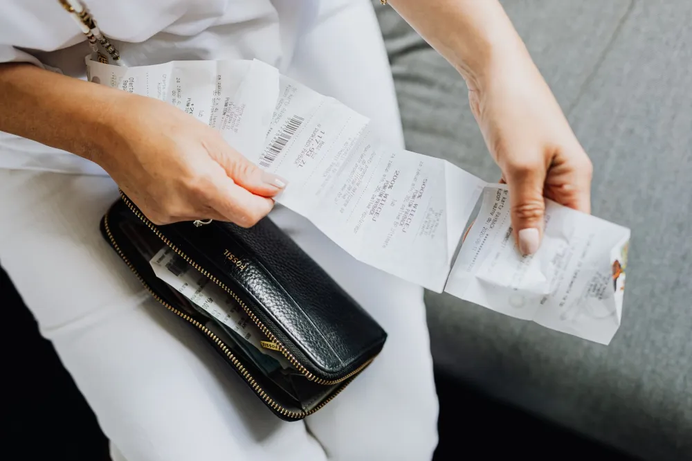 Woman at kitchen table reviewing a pharmacy receipt to compare Wegovy cost options